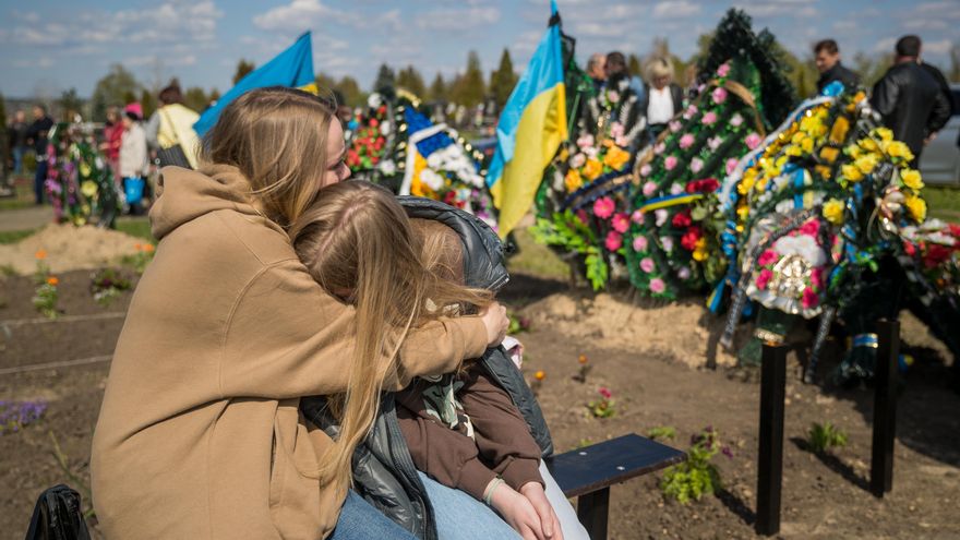 Dos mujeres se abrazan junto a la tumba de su familiar muerto en un cementerio, hoy domingo 1 de mayo del 2022 en Horodyshche (Ucrania). Los ucranianos celebran el domingo posterior a la Pascua Ortodoxa su día de muertos, y por eso hoy los cementerios del país se han llenado de familias que visitaban sus tumbas con flores y dulces, como manda la tradición, y no han sido pocas las que han tenido que recordar a sus soldados muertos en la guerra. EFE/Miguel Gutiérrez