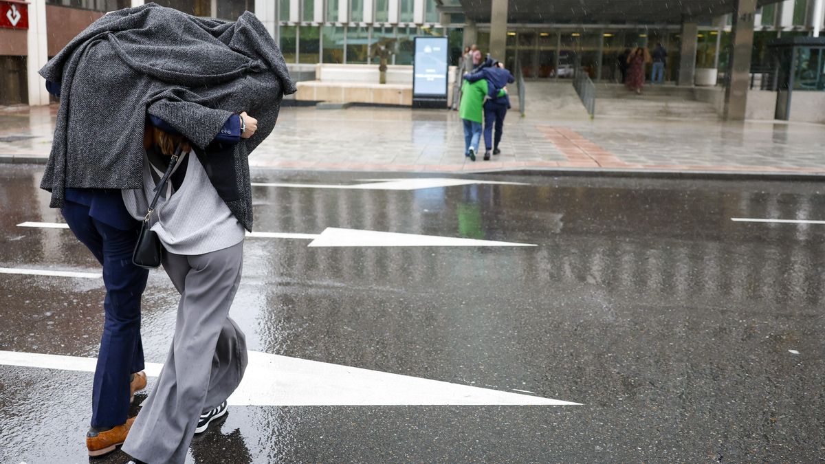 Varias personas se protegen de la lluvia en Madrid, en una foto de archivo