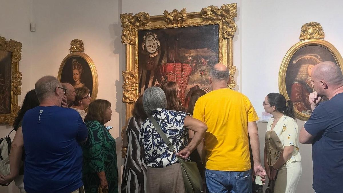 Visitantes del Museo de Bellas Artes de Xàtiva contemplan el cuadro de Felipe V boca abajo.