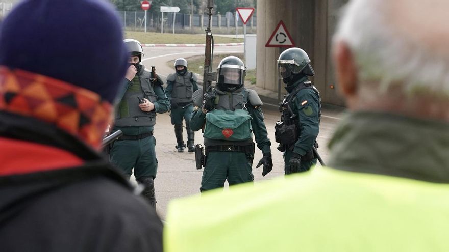 Antidisturbios y agricultores en una carretera de la red principal en la provincia de León.