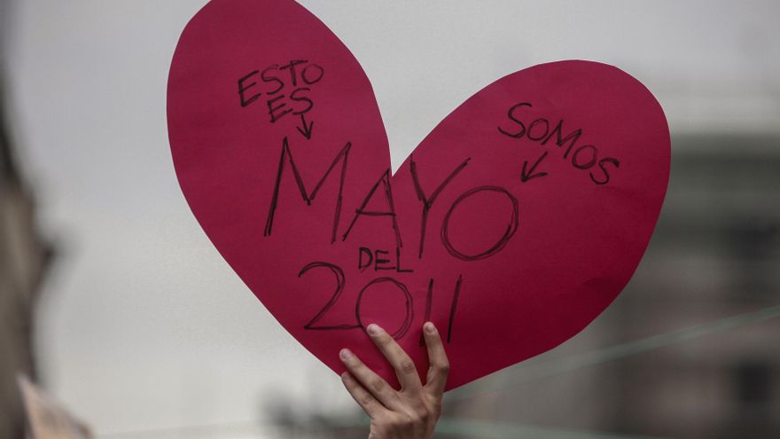 18/05/2011. Una manifestante sostiene un cartel en la Puerta del Sol.