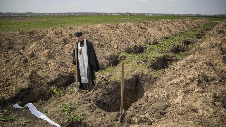 Un religioso observa una de las fosas durante el entierro del soldado ucraniano Mykola.