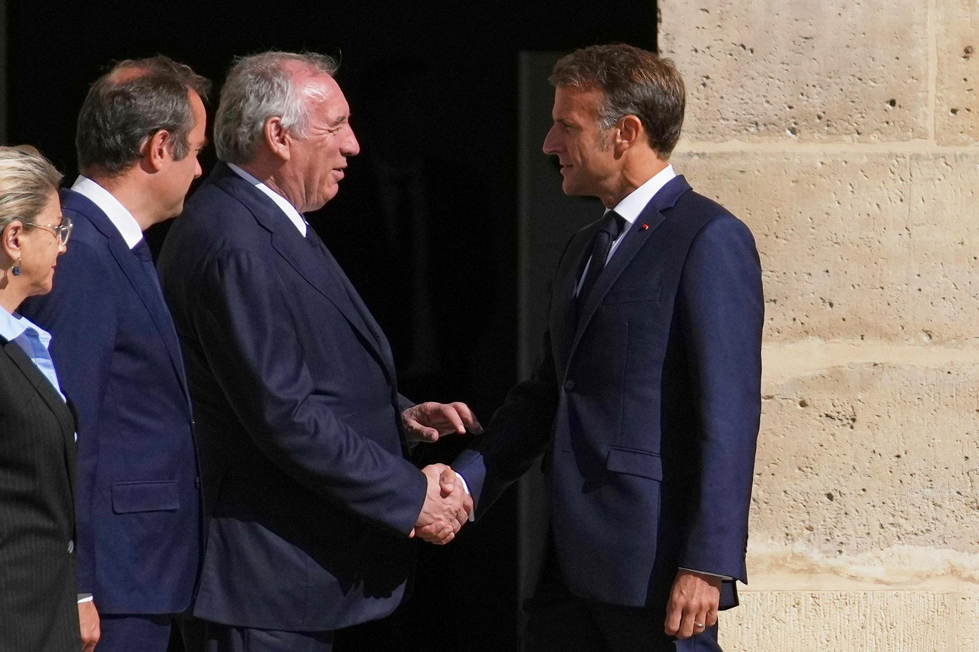 El presidente francés, Emmanuel Macron (derecha) saluda al primer ministro, Francois Bayrou.