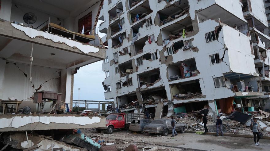 Residentes caminan entre los escombros de varios bloques de viviendas dañados por los terremotos en la localidad de Catia La Mar.