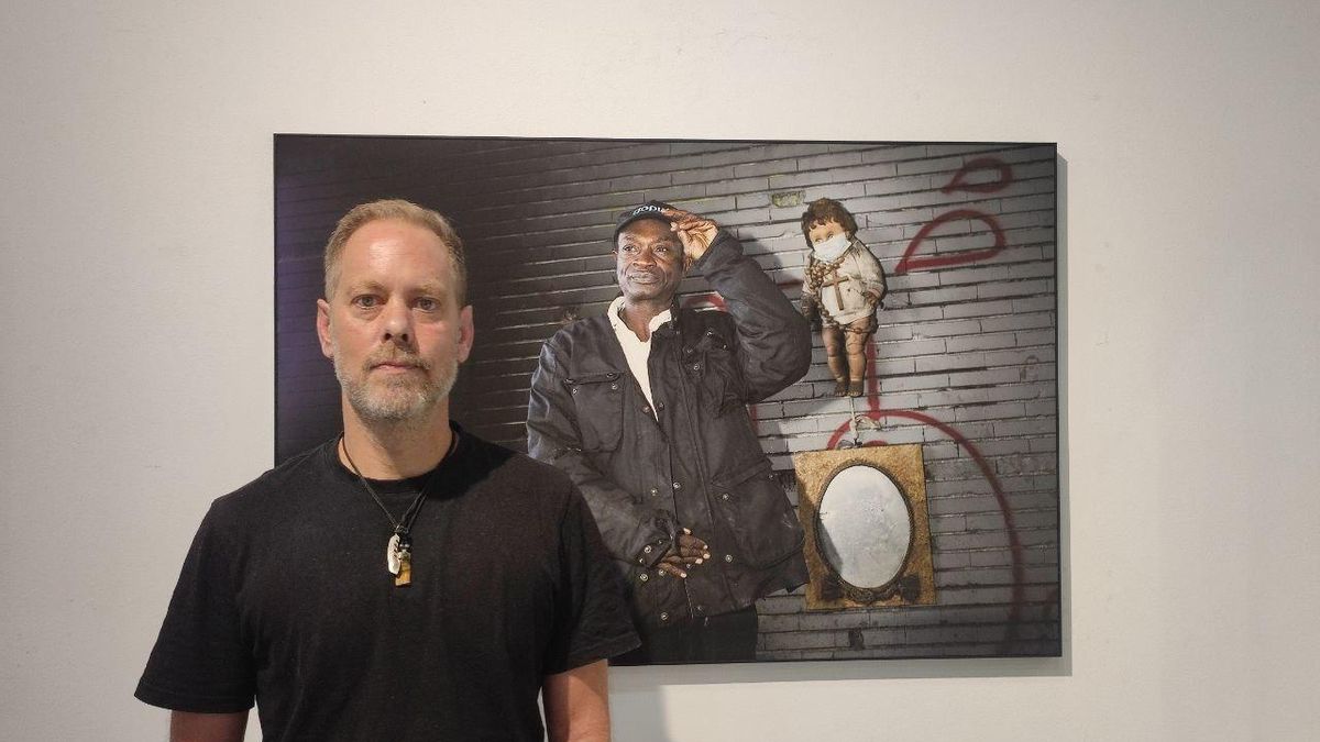 Edu León posa junto al retrato de John, una persona sin hogar que pernoctaba cerca de la M-30.