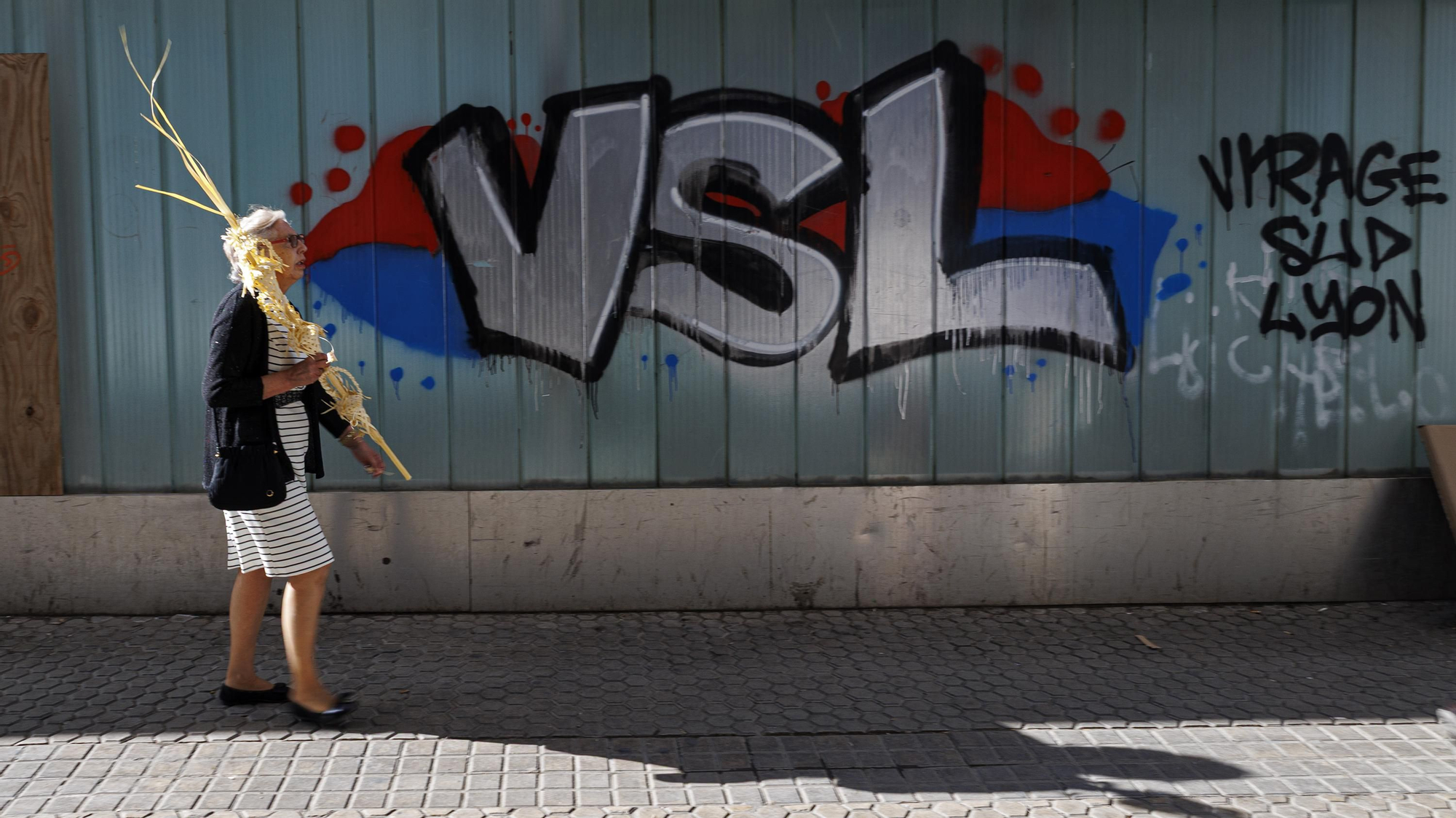 Una mujer porta una palma por las calles de Sevilla