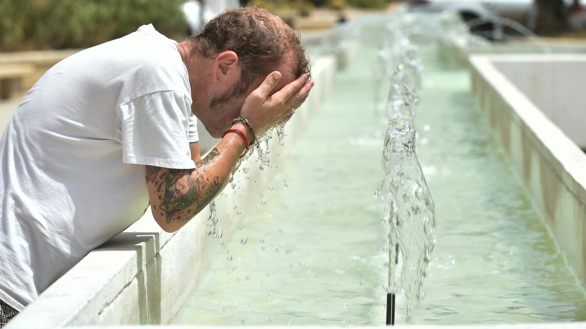 Un hombre se refresca en una fuente, a 10 de agosto de 2023, en Murcia,