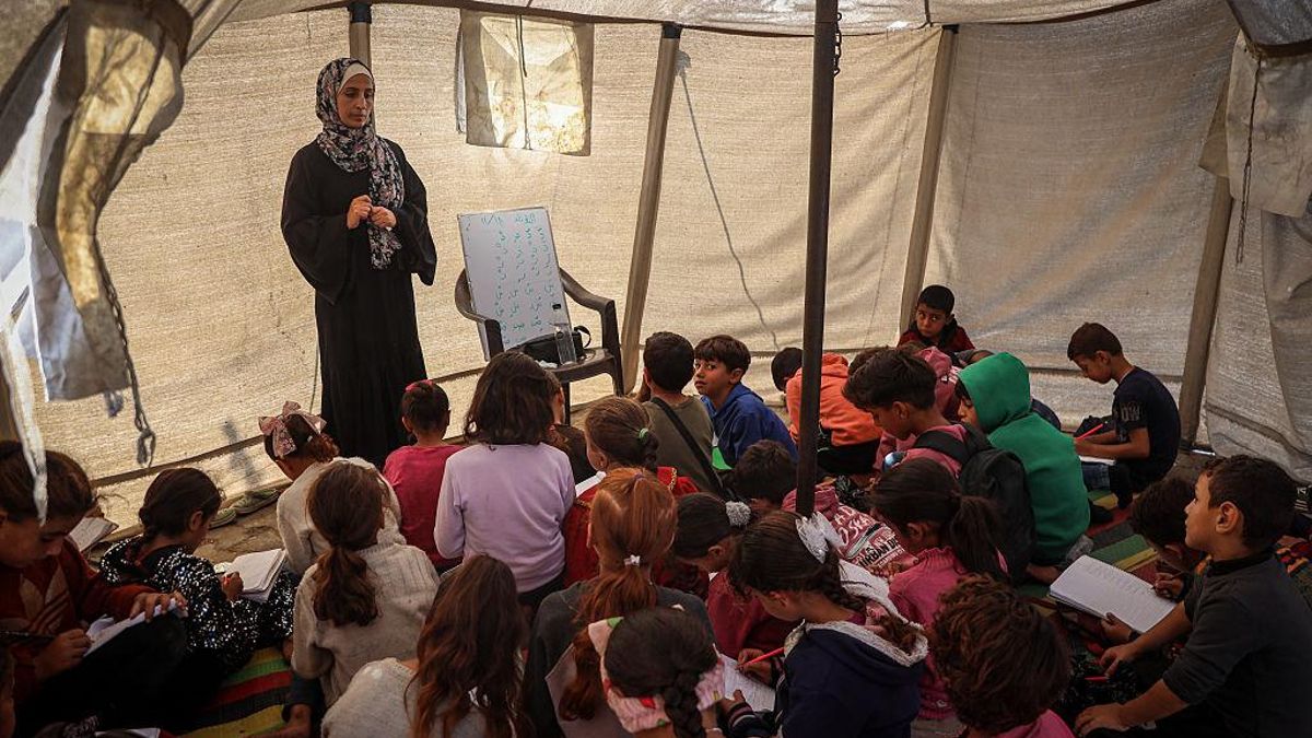 Niños y niñas gazatíes asisten a una clase en una carpa, en uno de los espacios de enseñanza temporales de Gaza, el 18 de noviembre de 2025.