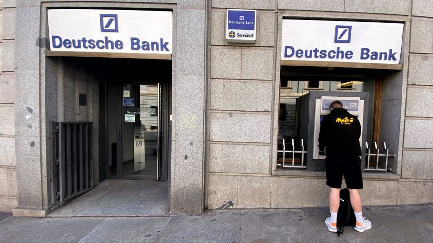 Un hombre retira dinero de un cajero Deutsche Bank, en Madrid (España), a 7 de febrero de 2020.