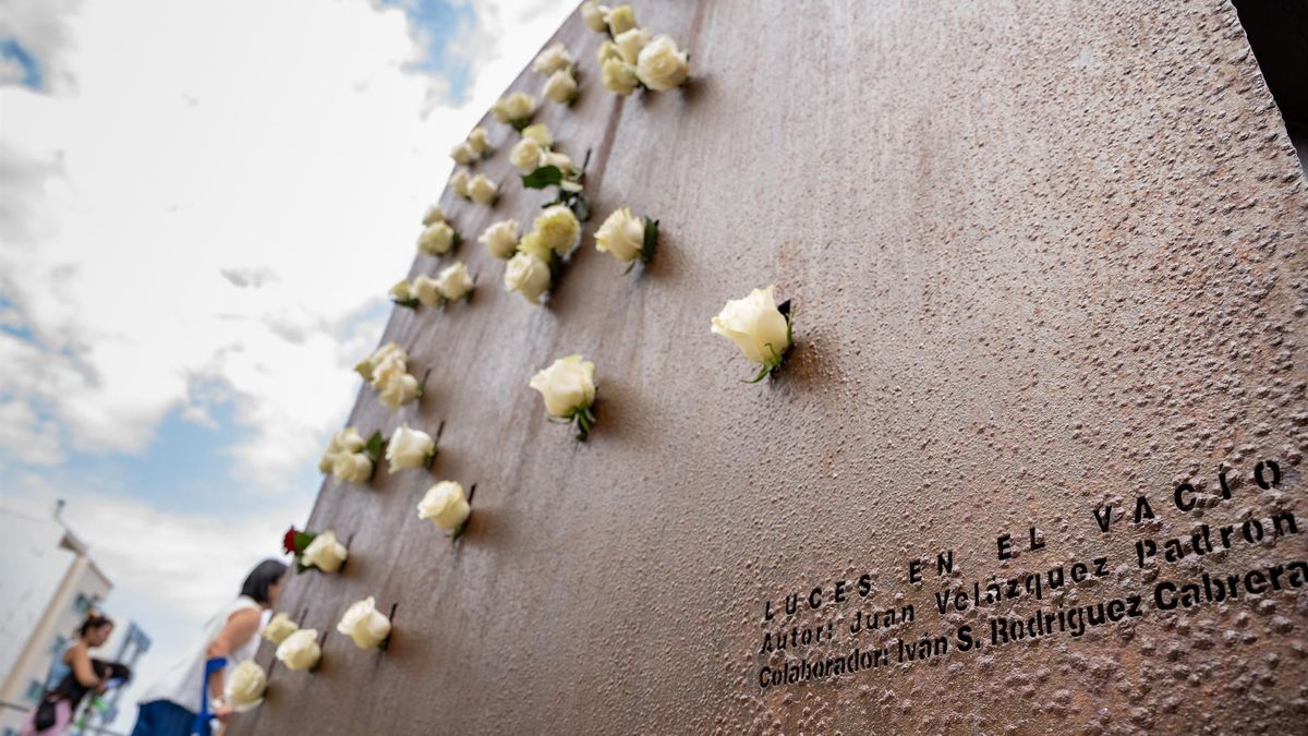 Varias personas depositan flores en el monumento por las víctimas durante la ofrenda floral por el aniversario de la tragedia de Spanair, en la playa de Las Canteras, a 20 de agosto de 2023, en Las Palmas de Gran Canaria