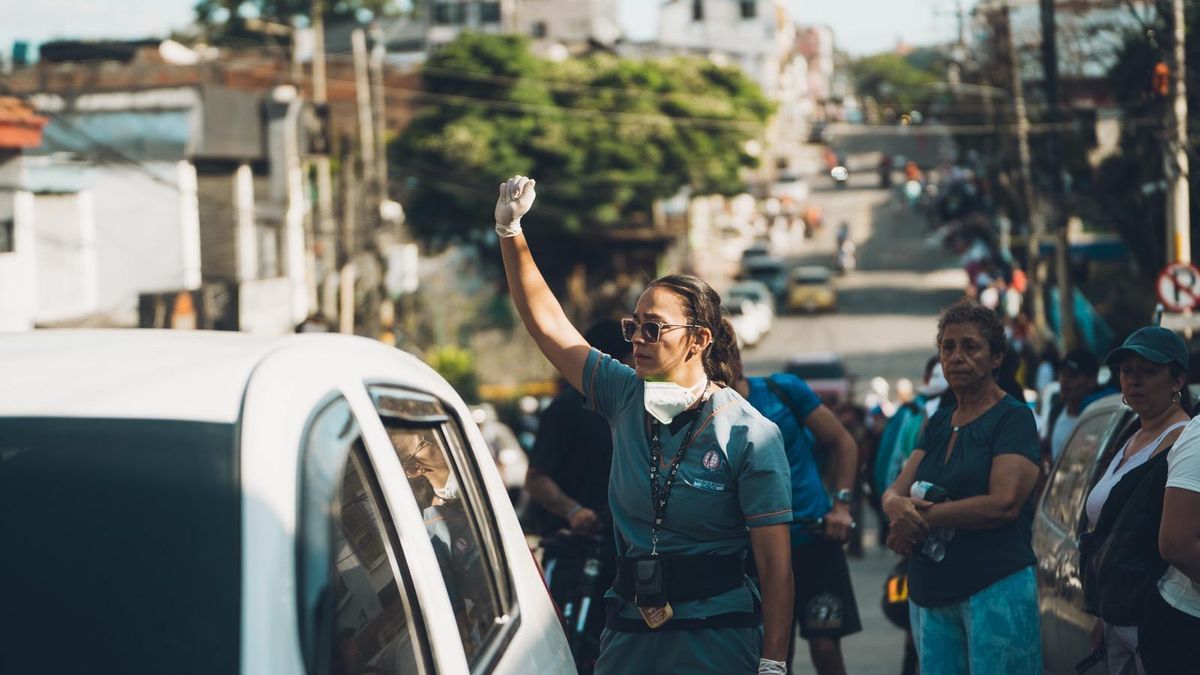 Una mujer levanta el brazo para pedir silencio durante un rescate de afectados por el terremoto en Colombia.