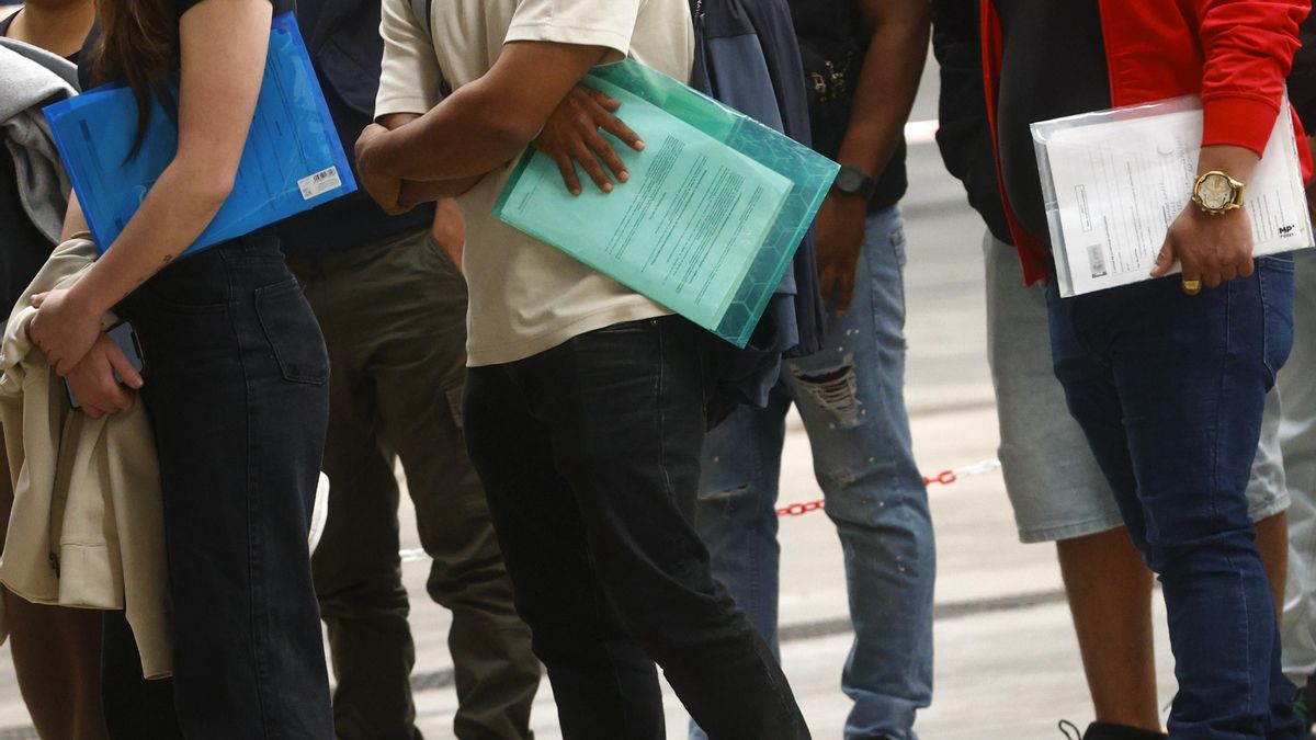 Imagen de archivo de centenares de personas migrantes haciendo cola en el recinto ferial La Farga de L'Hospitalet de Llobregat (Barcelona).