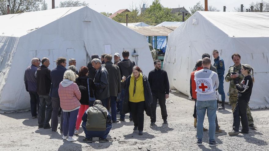 Un grupo de civiles se reúne en un centro de refugiados temporal en una localidad cercana a Mariúpol, tras ser evacuados de la planta de Azovstal con la ayuda de la ONU y la Cruz Roja.
