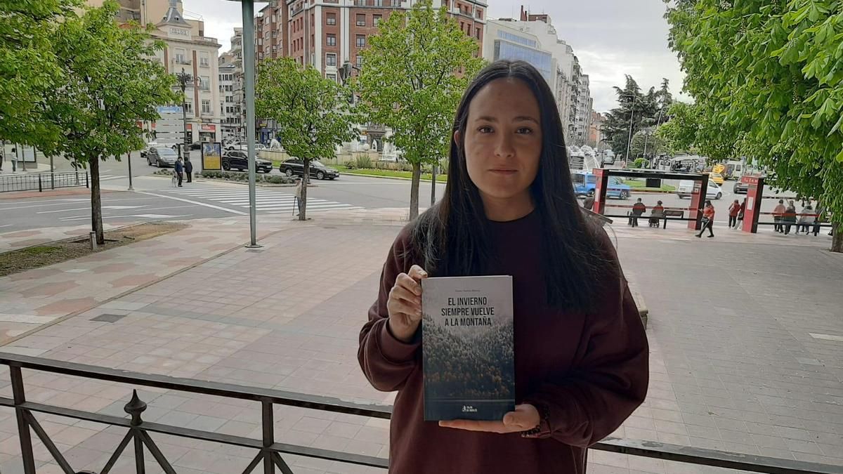 Noemí Suárez Blanco posa con su novela 'El invierno siempre vuelve a la montaña' en el paseo de la Condesa de León.