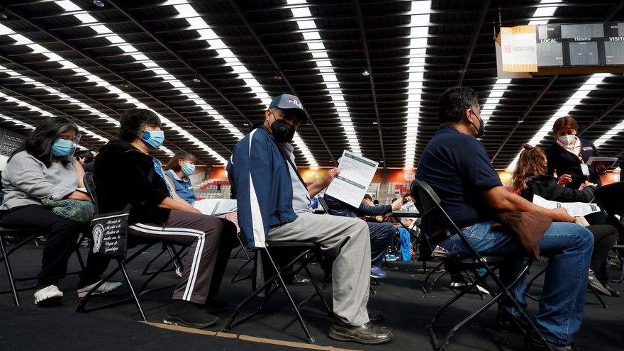 Cientos de personas de entre 50 y 59 años de edad asisten a un centro de vacunación contra la COVID-19 para recibir su tercera dosis en la Capital Mexicana.