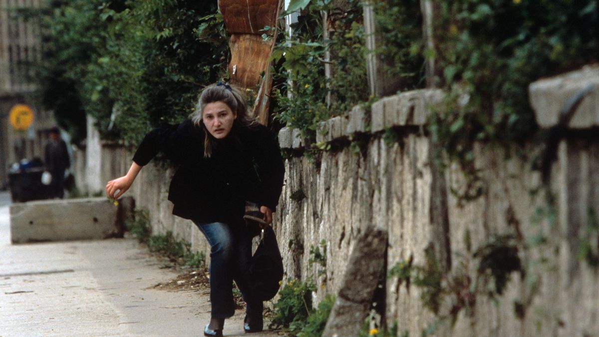Una mujer corre a refugiarse del intenso fuego de los francotiradores serbios en Sarajevo el 11 de junio de 1995.