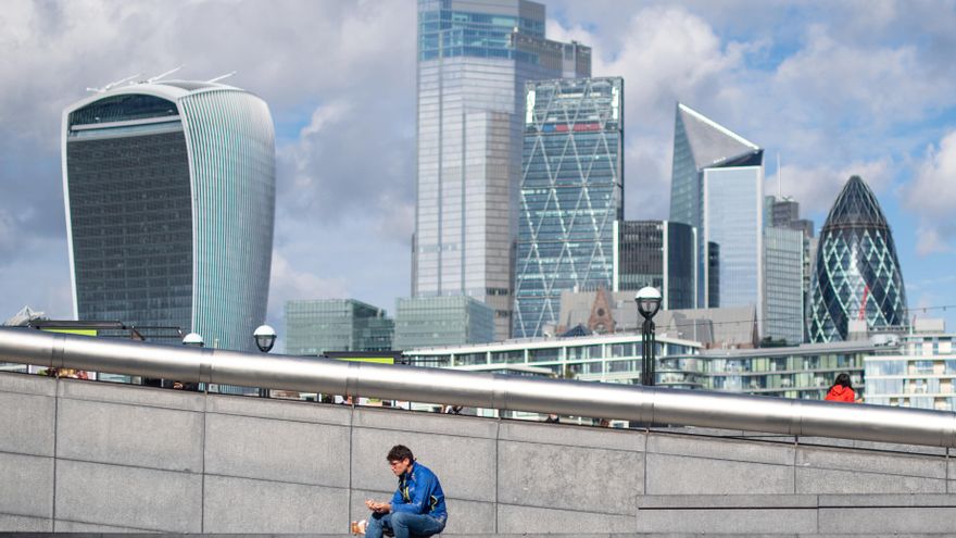 Un hombre se sienta y come cerca del Ayuntamiento, en Londres (Reino Unido).