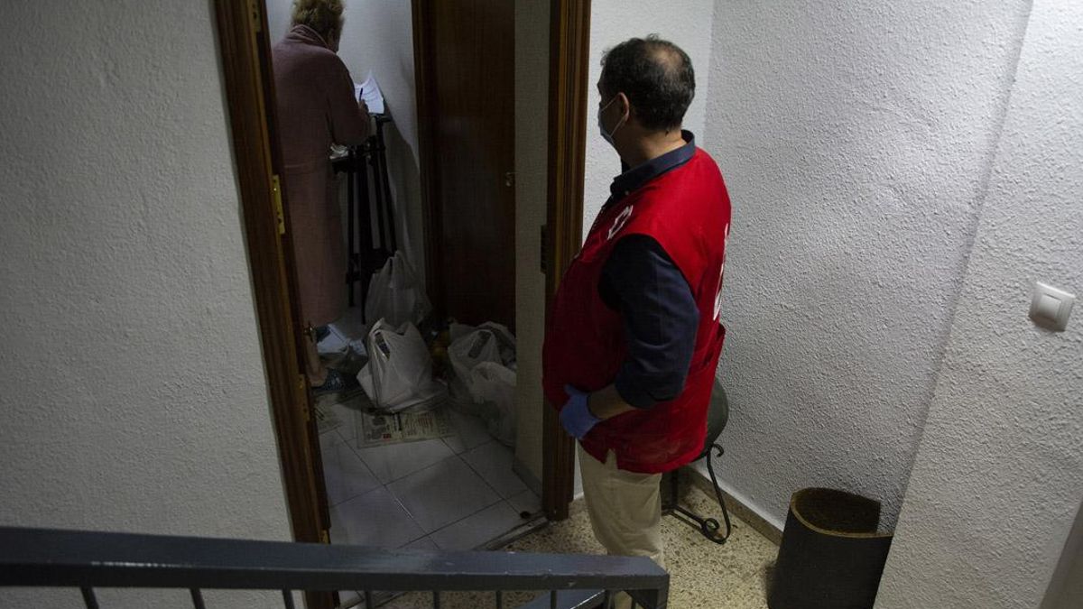 Un voluntario de Cruz Roja, atendiendo a una persona mayor.