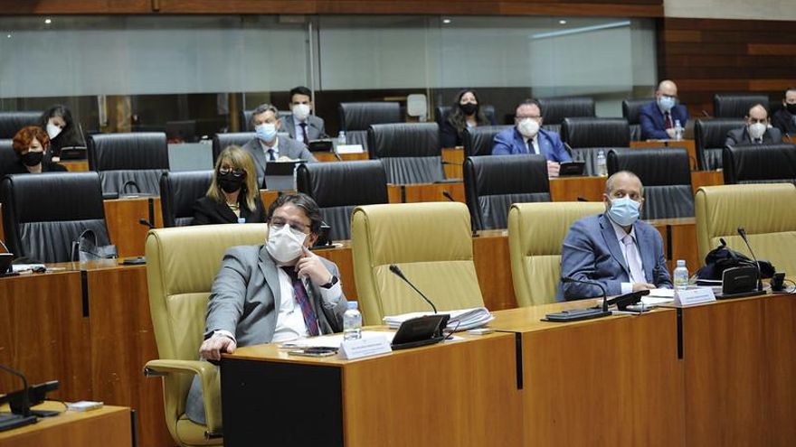 Consejero de Sanidad, consejero de Economía, y otros diputados, escuchando una intervención de Vara