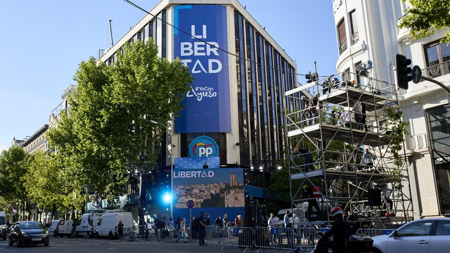 Sede del PP con lonas colgadas en su fachada minutos antes de que comience el recuento de las votaciones de la jornada electoral