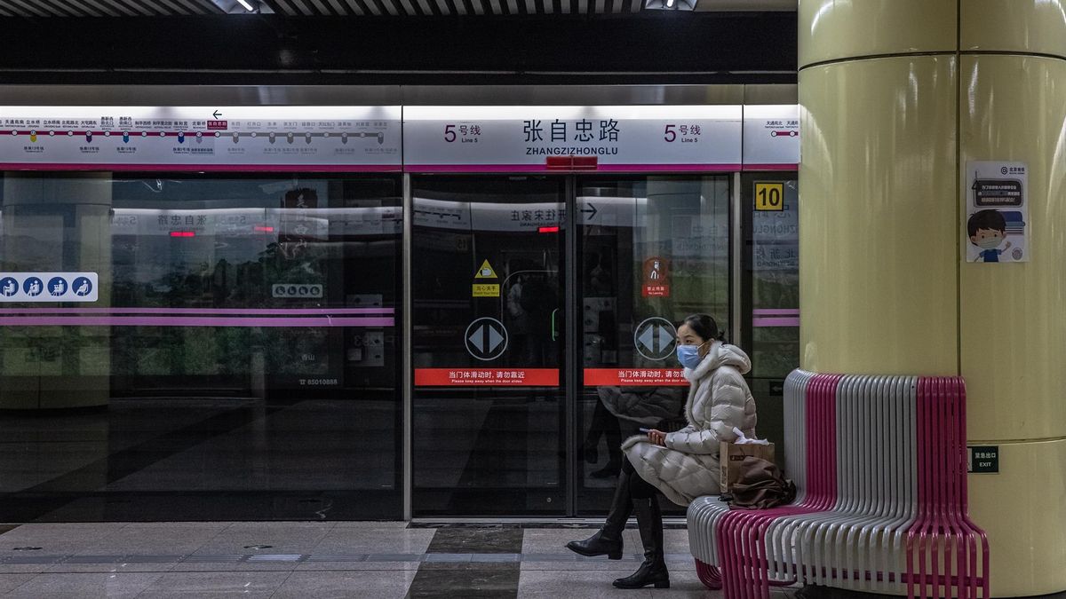 A passenger wearing a face mask waits for a subway on a station, in Beijing, China, 20 January 2022.