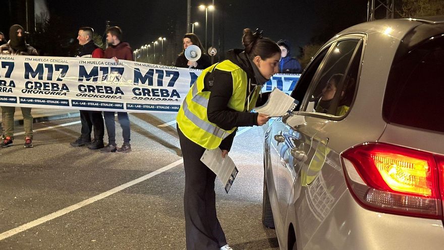 Una huelguista reparte propaganda en un vehículo