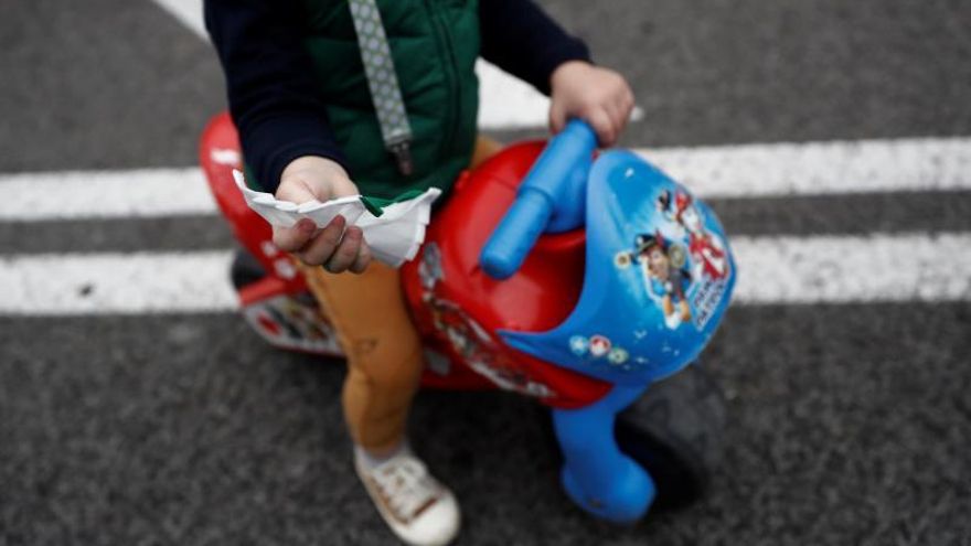 Un niño muestra una mascarilla en el Paseo de la Castellana, en Madrid.