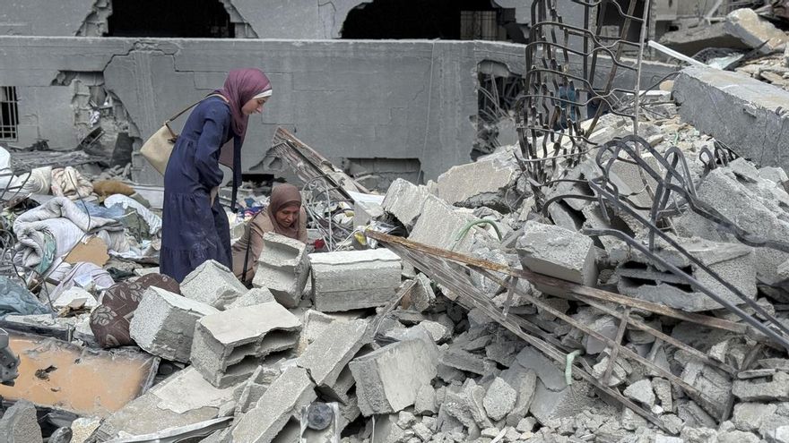 Unos ciudadanos gazatíes intentan salvar este lunes algunas de sus pertenencias entre los escombros de la torre Al Jundi, en la ciudad de Gaza, que fue derribada ayer, domingo, por el ejército de Israel.