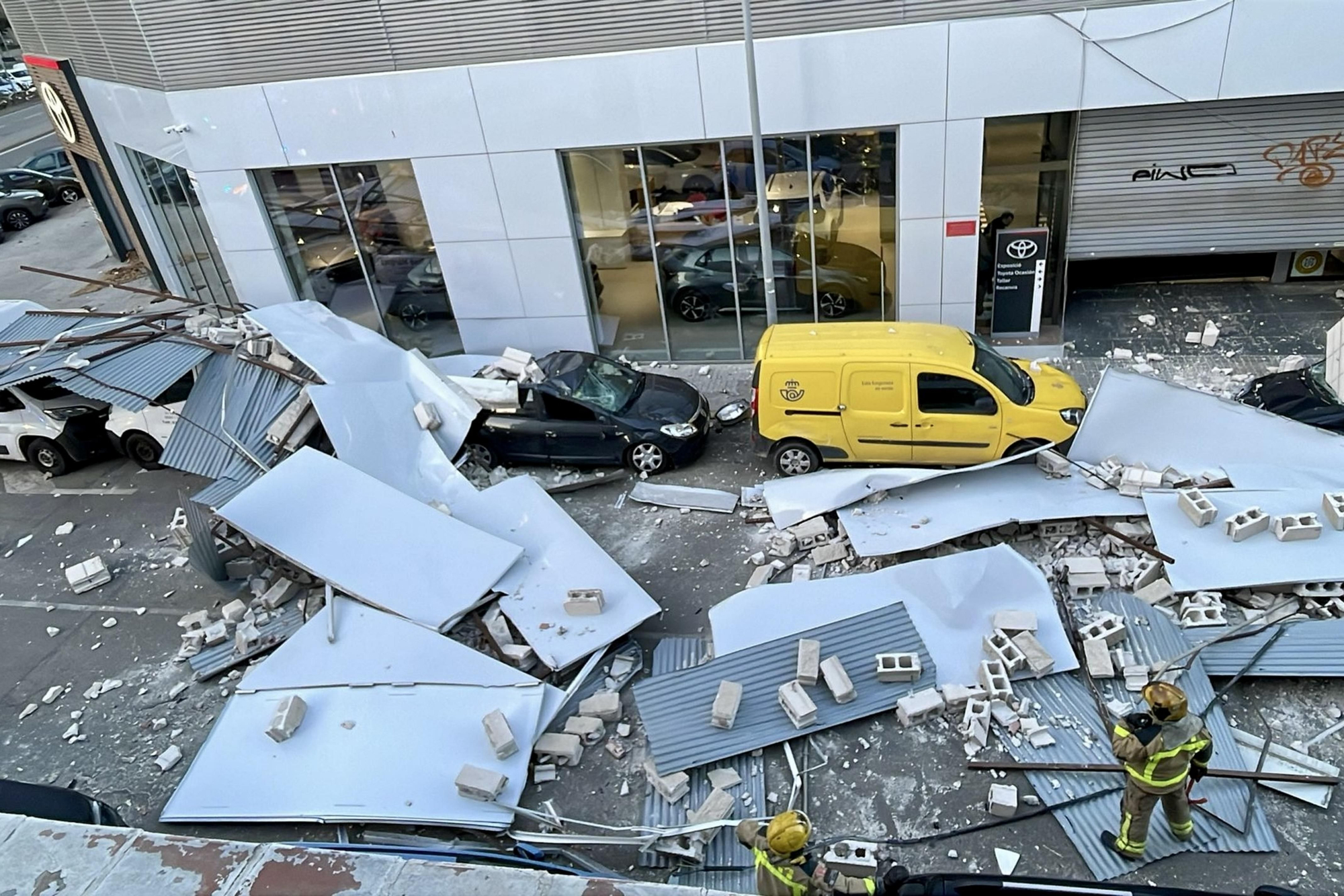 Un muro de un taller cae sobre los coches en la calle, en L'Hospitalet de Llobregat