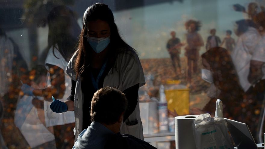 Una profesional sanitaria vacuna a una mujer en Barcelona.