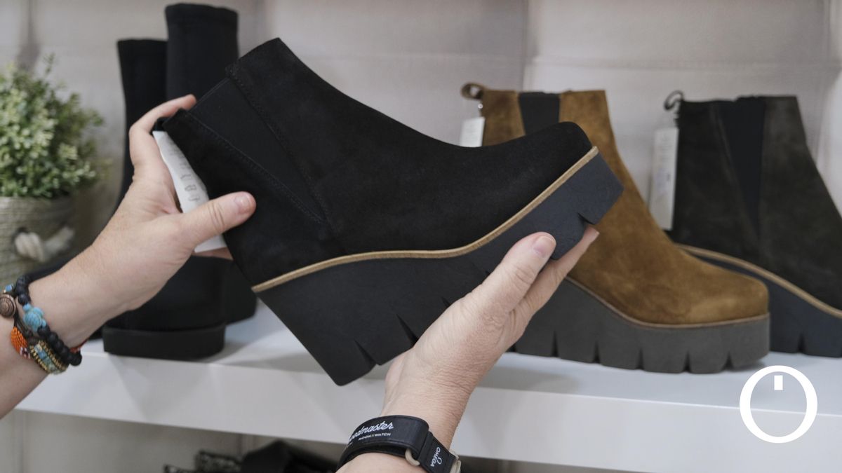 Una dependienta colocando unos zapatos en una tienda