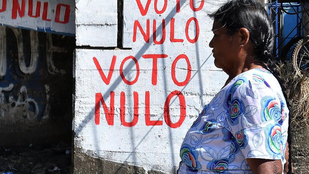 Una mujer quechua camina frente a un aviso por el voto nulo este sábado, en Entre Ríos, la región boliviana del Trópico de Cochabamba, bastión político y sindical del expresidente Evo Morales.