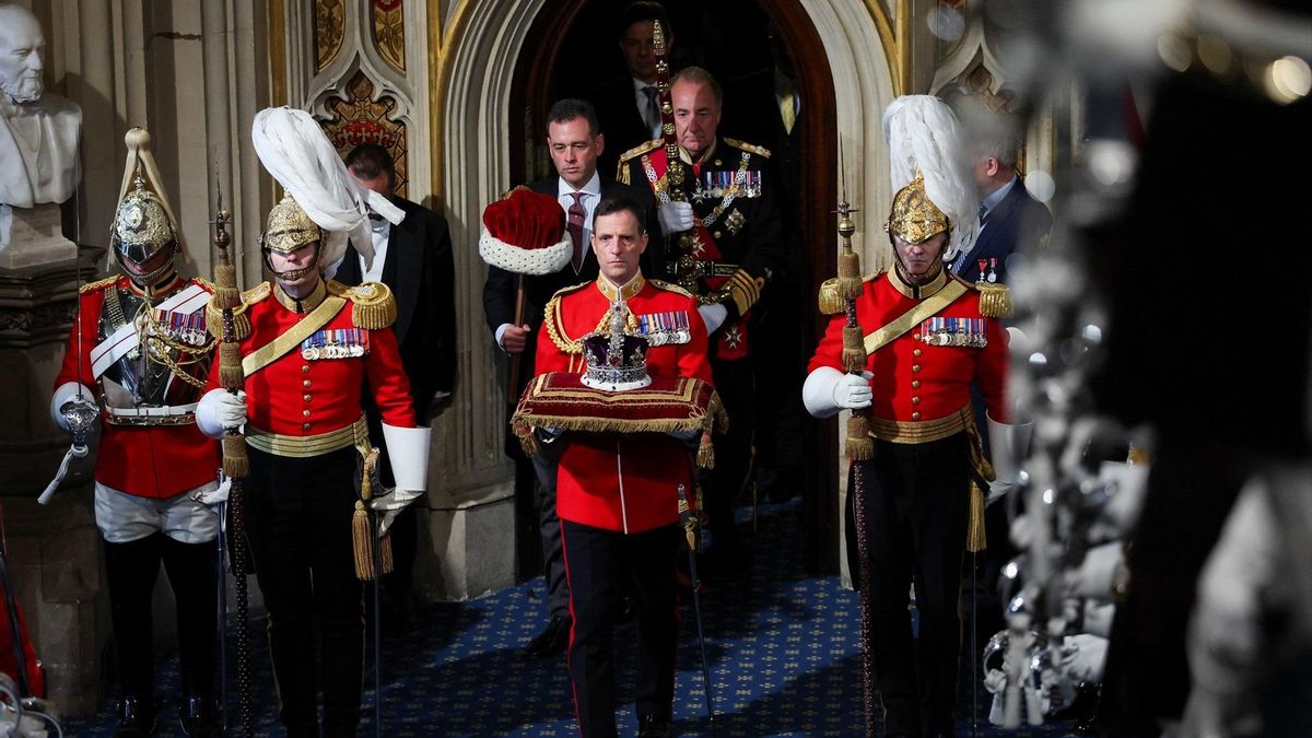 Un guardia entra en el Parlamento británico con la corona de Carlos III para su discurso del rey este miércoles.