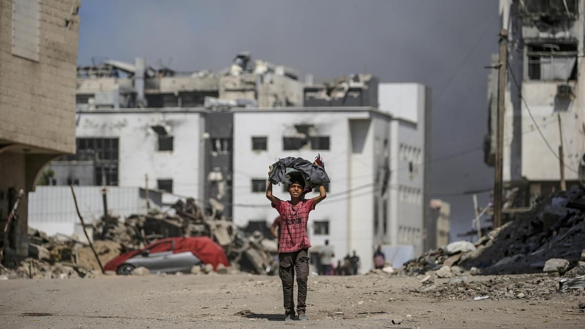 Un niño palestino camina mientras se eleva el humo tras un ataque aéreo israelí cerca del hospital Al-Shifa en la ciudad de Gaza, Franja de Gaza, el 28 de septiembre de 2025