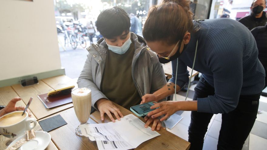 Una camarera comprueba el pasaporte covid de un cliente en un bar del barrio de Gracia de Barcelona, en una imagen de archivo. EFE/Marta Pérez