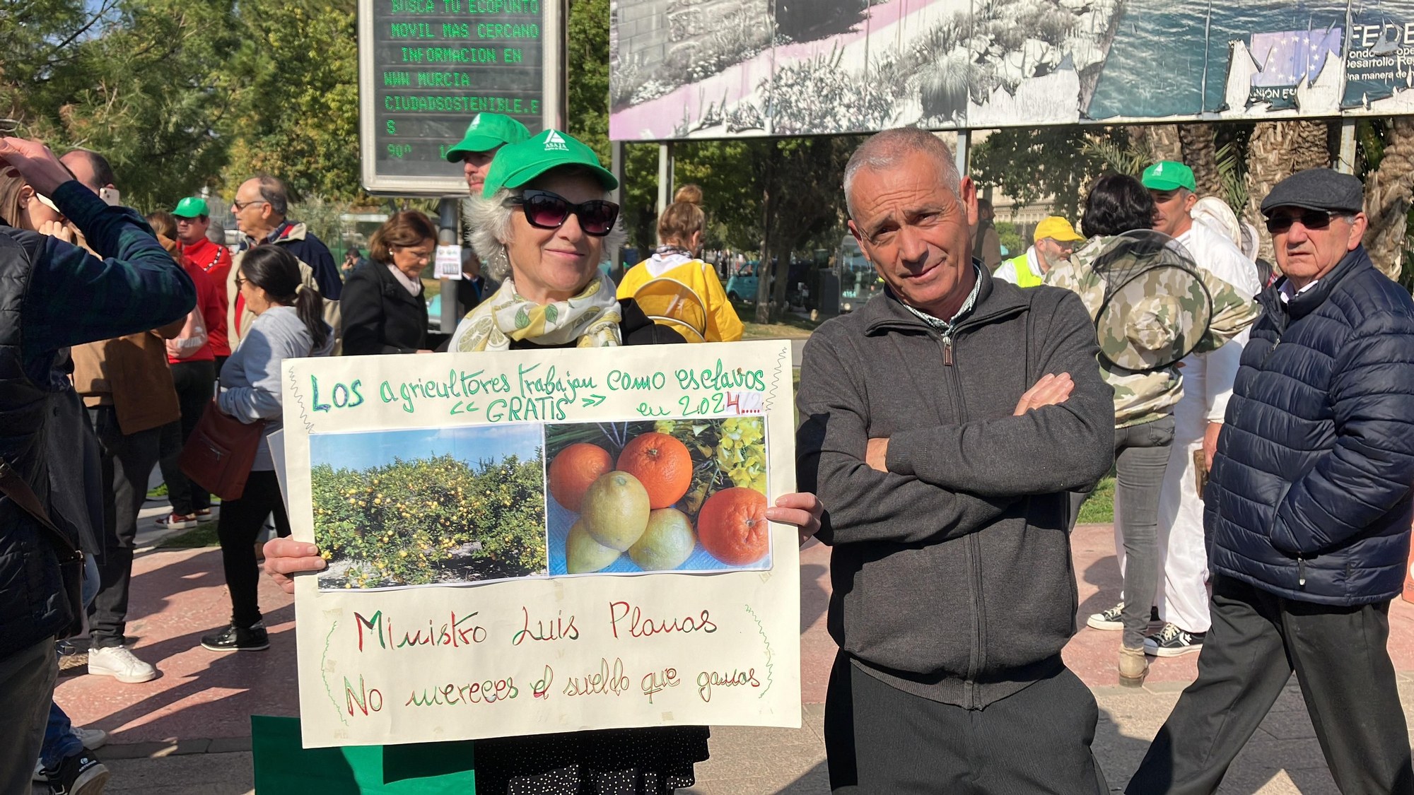 Dos agricultores con una pancarta que asegura que los agricultores trabajan "gratis como esclavos": "ministro Luis Planas, no mereces el sueldo que ganas"