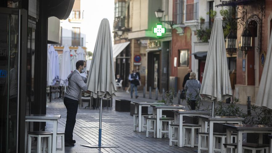 Un camarero colocando veladores.