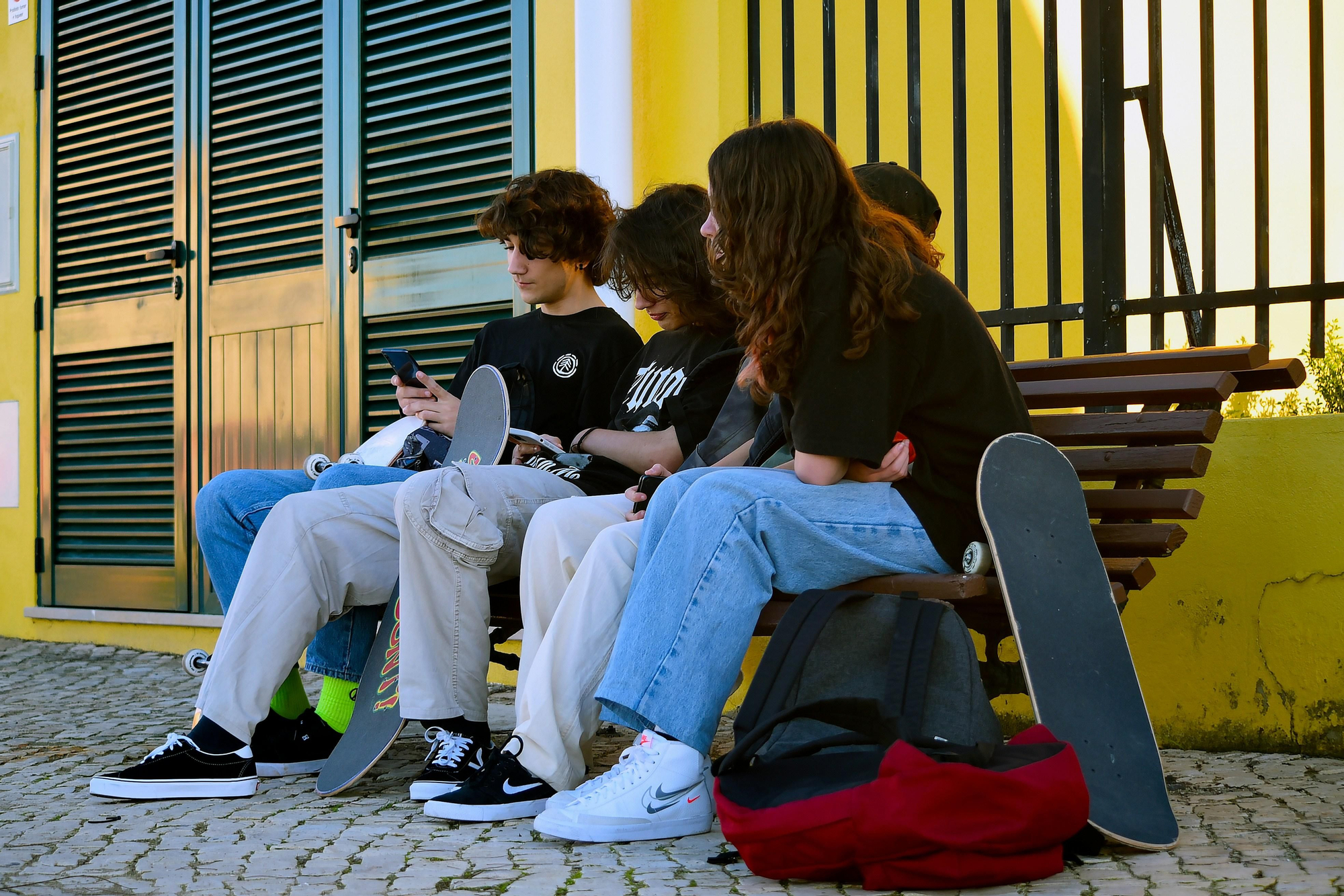 Un grupo de adolescentes que han quedado para patinar pero están utilizando el teléfono móvil