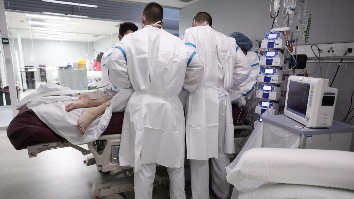 Varios sanitarios atienden a una paciente en la UCI.