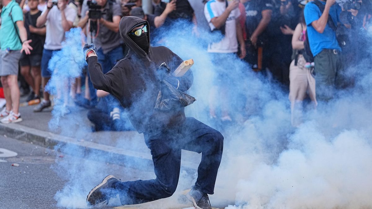 Un manifestante devuelve una cápsula de gas lacrimógeno hacia la policía durante la manifestación.