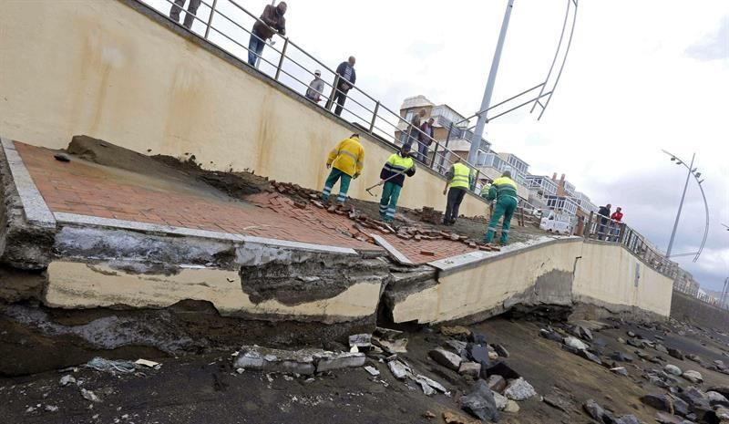Operarios del Ayuntamiento de Las Palmas de Gran Canaria reparan los desperfectos causados por el fuerte oleaje en varios de los accesos de la playa de Las Canteras, donde se han producido un desnivel de metro y medio. EFE/Elvira Urquijo A.