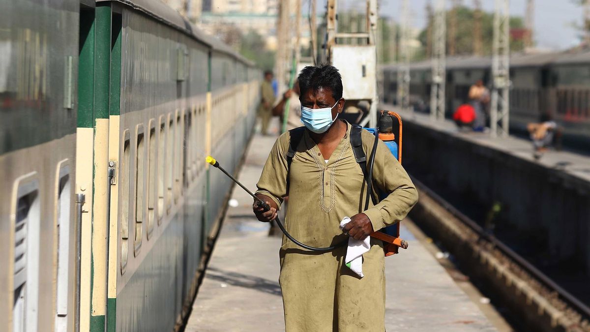 A worker sprays disinfectant on a train after new cases of COVID-19 were reported, in Karachi, Pakistan, 31 January 2022. The Omicron strain is continuing to spread across Pakistan amid the fifth wave of the pandemic, according to data from the National Command and Operation Center (NCOC).