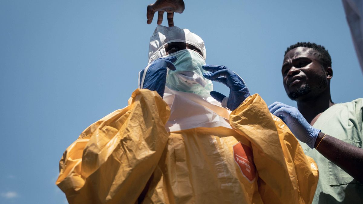 Compañeros de MSF ayudan a una higienista a colocarse el equipo de protección individual (EPI) antes de entrar en un centro de salud en Mongbwalu.