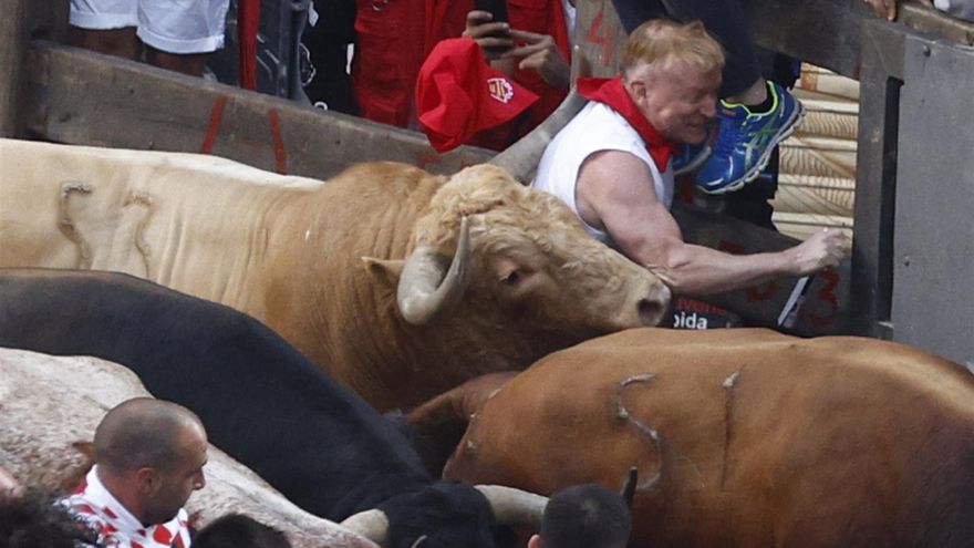 Un  mozo es alcanzado por uno de los toros de la ganadería gaditana Núñez del Cuvillo a su llegada a la curva de la calle Estafeta durante el primer encierro de los Sanfermines 2022. EFE/Rodrigo Jiménez