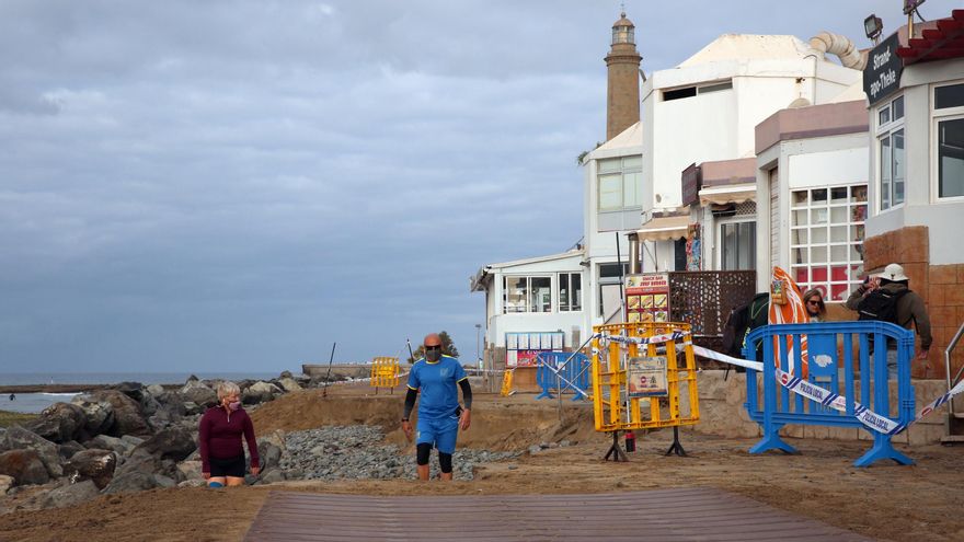 Varias personas en el tramo afectado del paseo de la playa de Maspalomas.