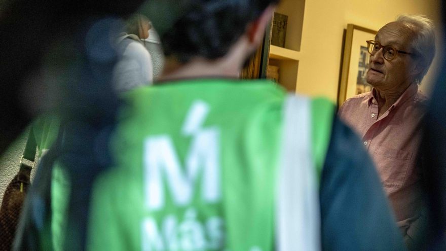 Un vecino atiende a los voluntarios que visitan su piso en Chamberí