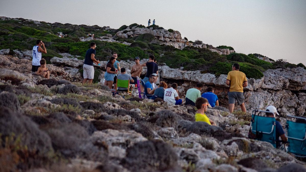 Decenas de personas esperan que la Luna cubra el Sol en Cala Morell (Menorca)