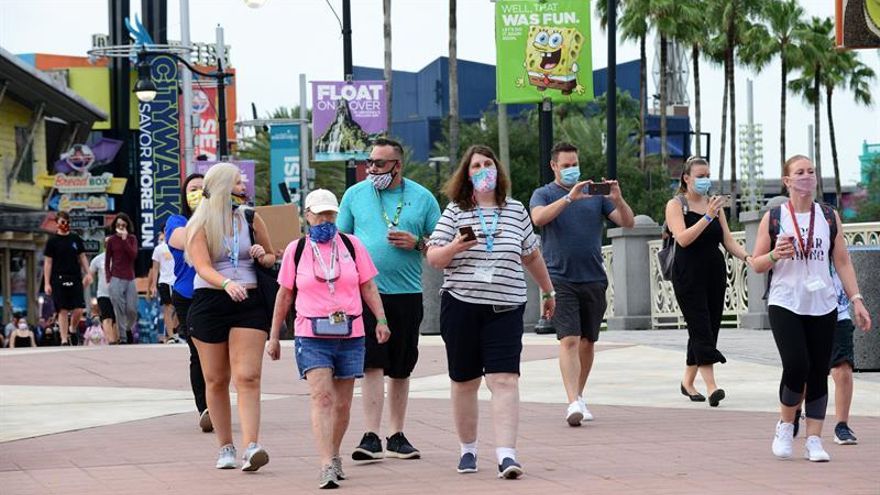 Varias personas con tapabocas caminan por el parque temático de Universal Studios en Orlando, Florida (EE.UU).