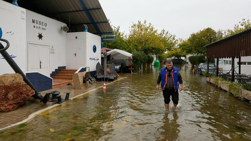 Un hombre camina con el agua por los tobillos por el camping Coelius, uno de los alojamientos de este tipo de la localidad de Oliva, muy afectados por las lluvias.