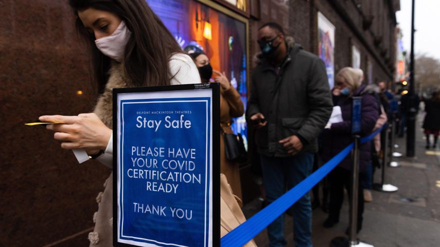 Cola ante un teatro en Londres el sábado junto al cartel que avisa para tener listo el pasaporte Covid.